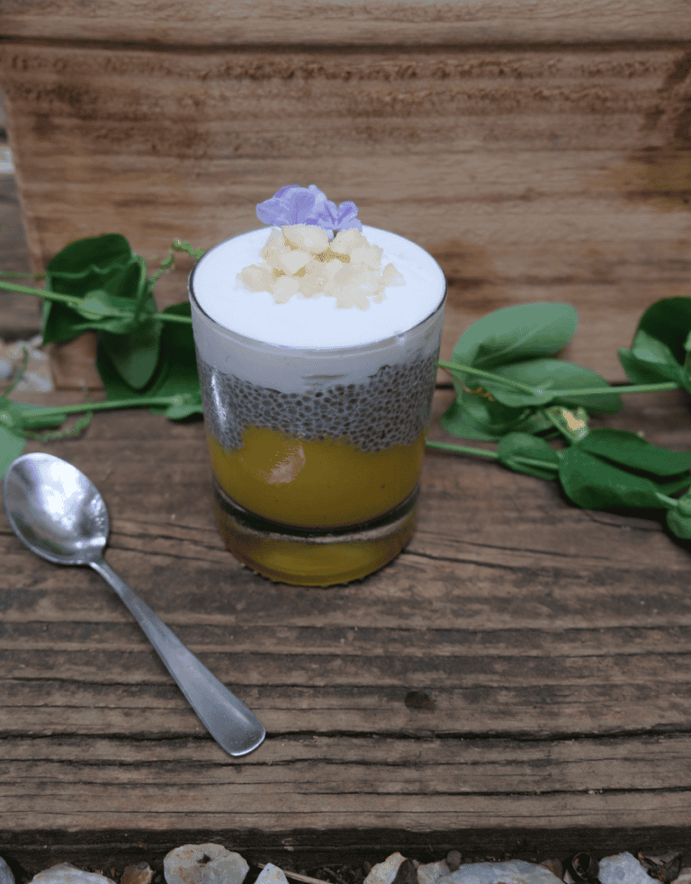 layered cup of coconut pudding with mango pure and coconut yoghurt