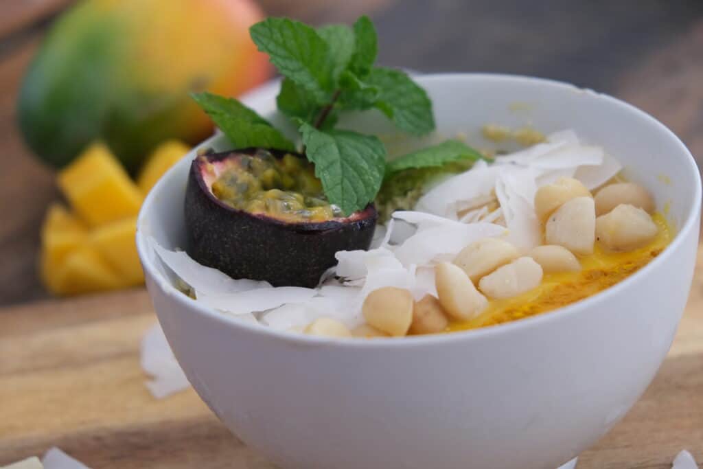 mango smoothie bowl with coconut, macadamias and passionfruit