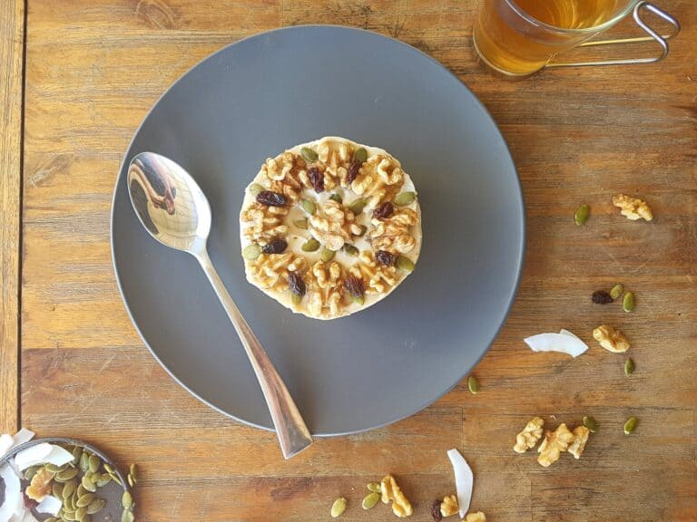 raw carrot cake from above with spoon and nuts sprinkled around