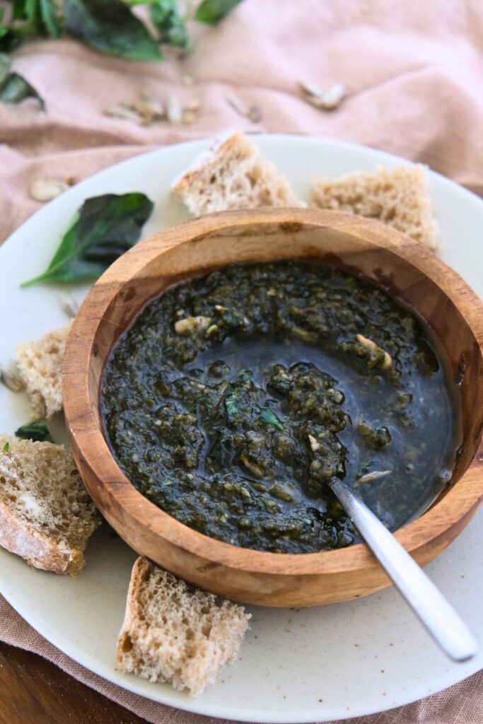 basil sunflower seed pesto in wood bowl with spoon